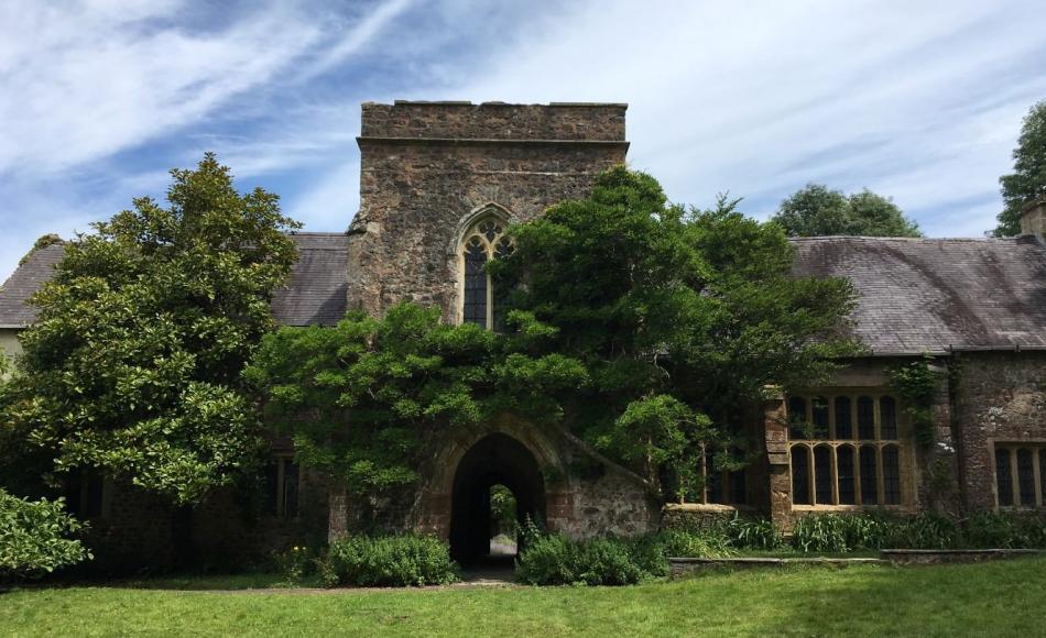 A view of the front of the manor house with its arched entrance and tower over