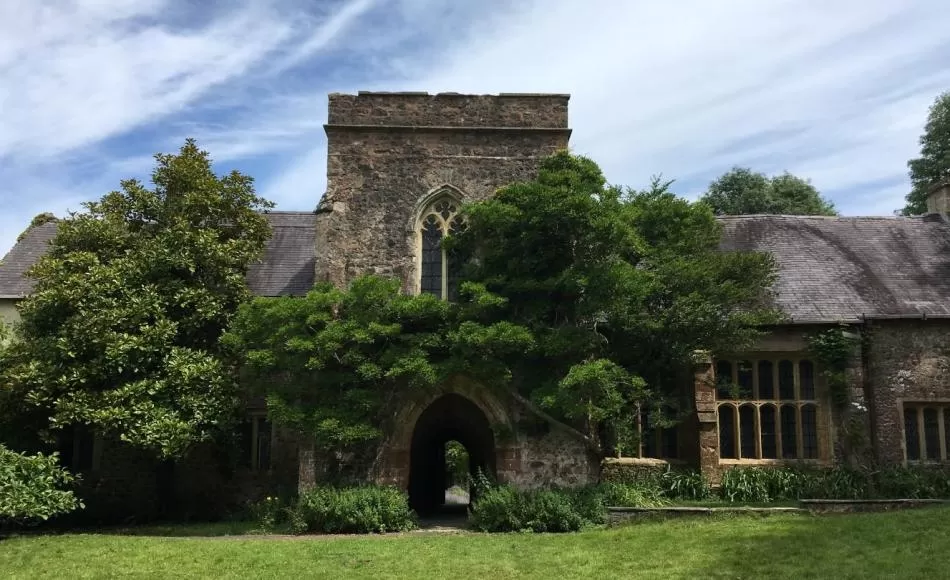 A view of the front of the manor house with its arched entrance and tower over