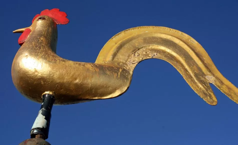 Weathered gilding to the golden cockerel weather vane at the top of the spire 