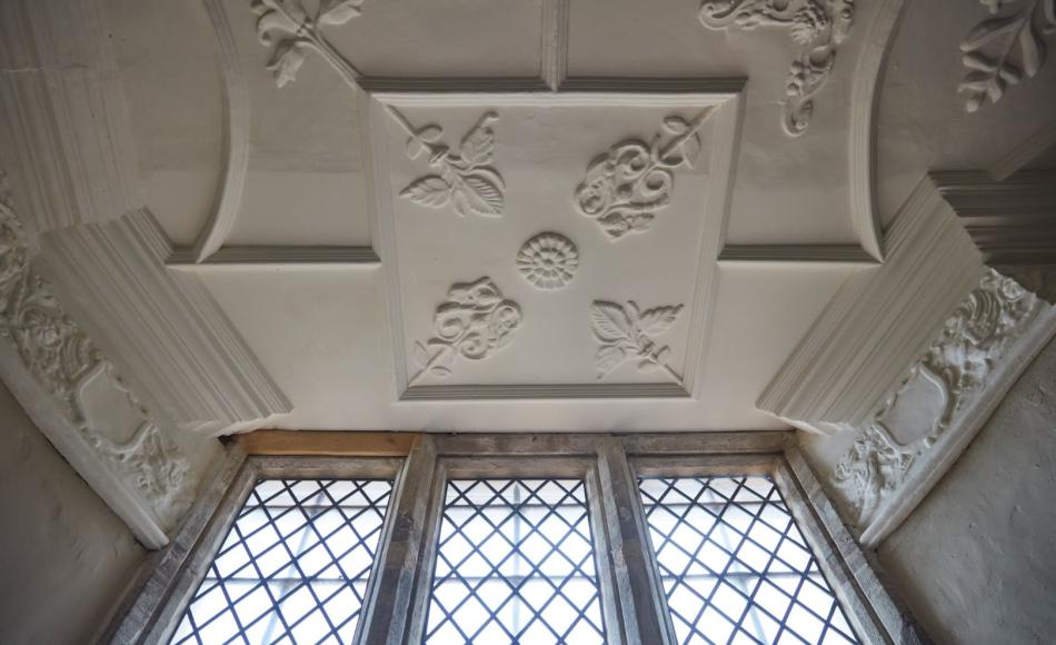 The decorative plasterwork ceiling above a restored window