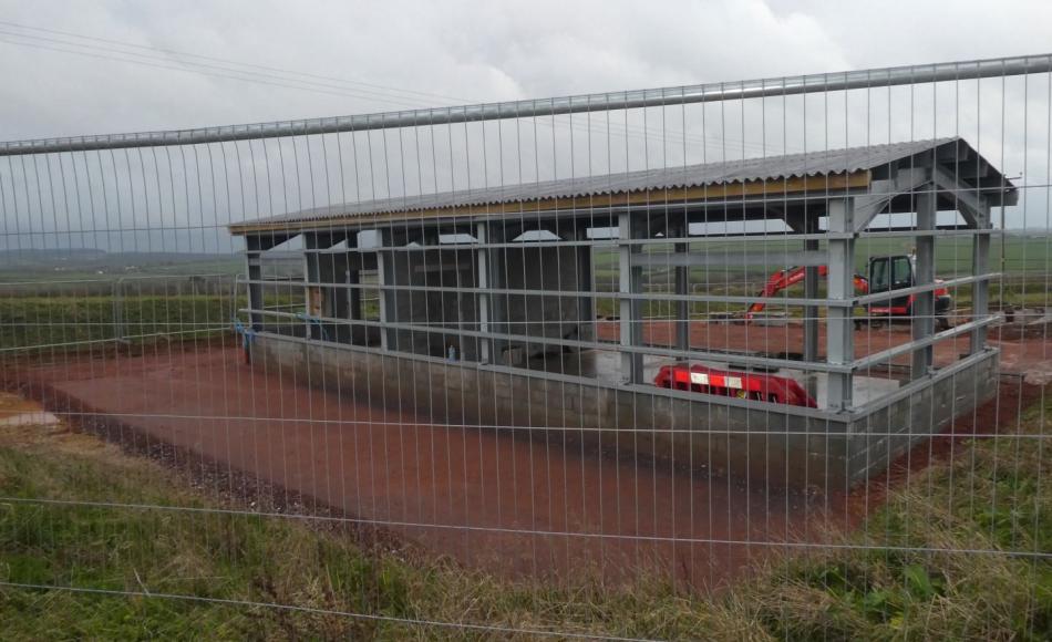 The vehicle shed with glimpses of the views from the farm over the Devon landscape 