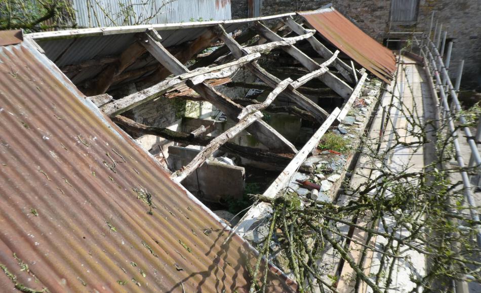 The corrugated tin roof covering probably replaced earlier thatch
