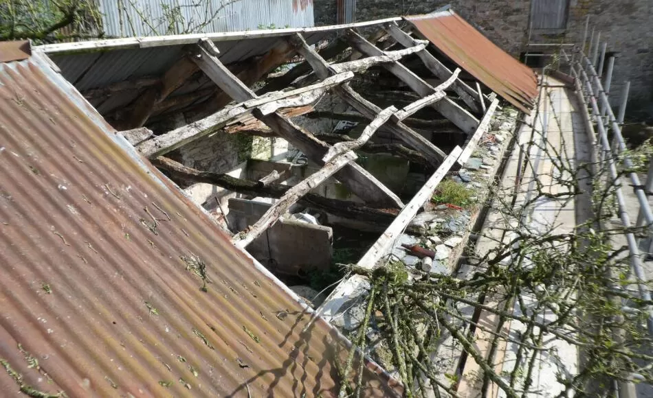 The corrugated tin roof covering probably replaced earlier thatch