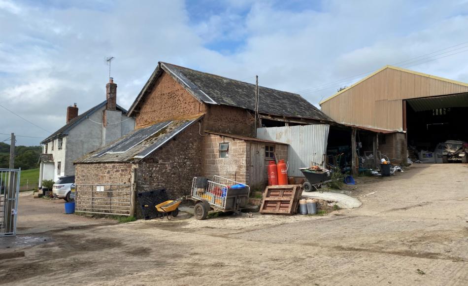 The historic threshing barn is currently concealed behind unused modern sheds