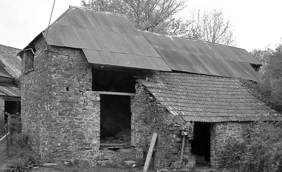 Before repairs - Devon barn previously re-roofed in metal sheet in need of masonry and joinery repairs.