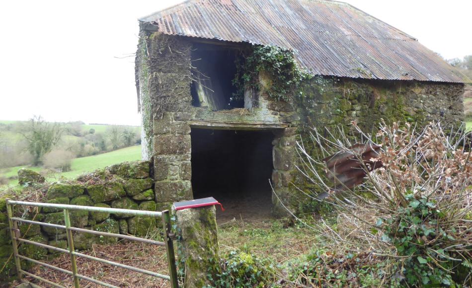 Agricultural building prior to repair with raised roof profile of loft door