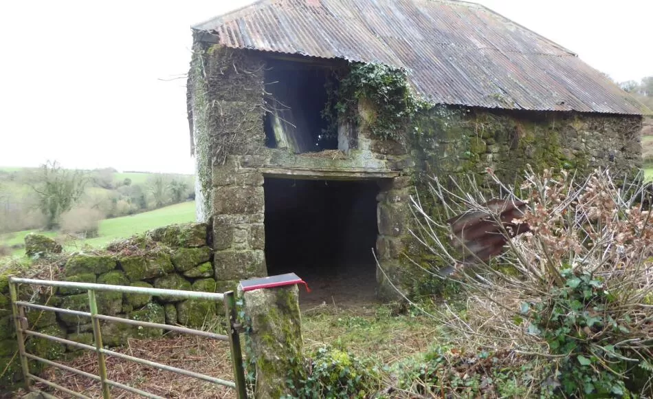 Agricultural building prior to repair with raised roof profile of loft door