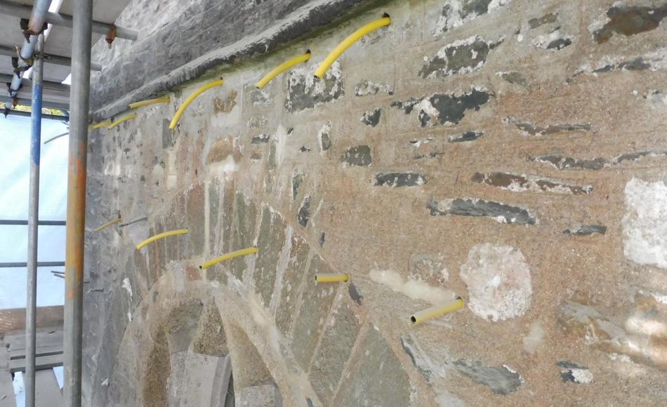 Holes drilled in tower walls ready to receive pumped runny lime mortar (grout) to fill voids in core of wall.