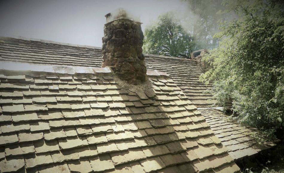 Wellhouse with fire and oven set behind the farmhouse and built into hillside